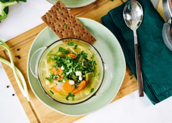 One plate with vegan food, cabbage soup and on the table at home Serving vegan cooked dishes in a green dish top view,